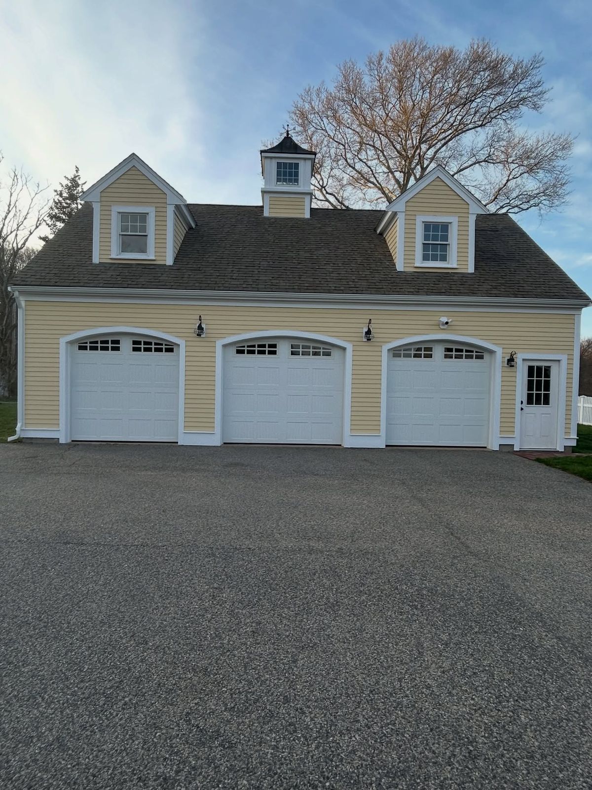 Yellow carriage house and three-car garage