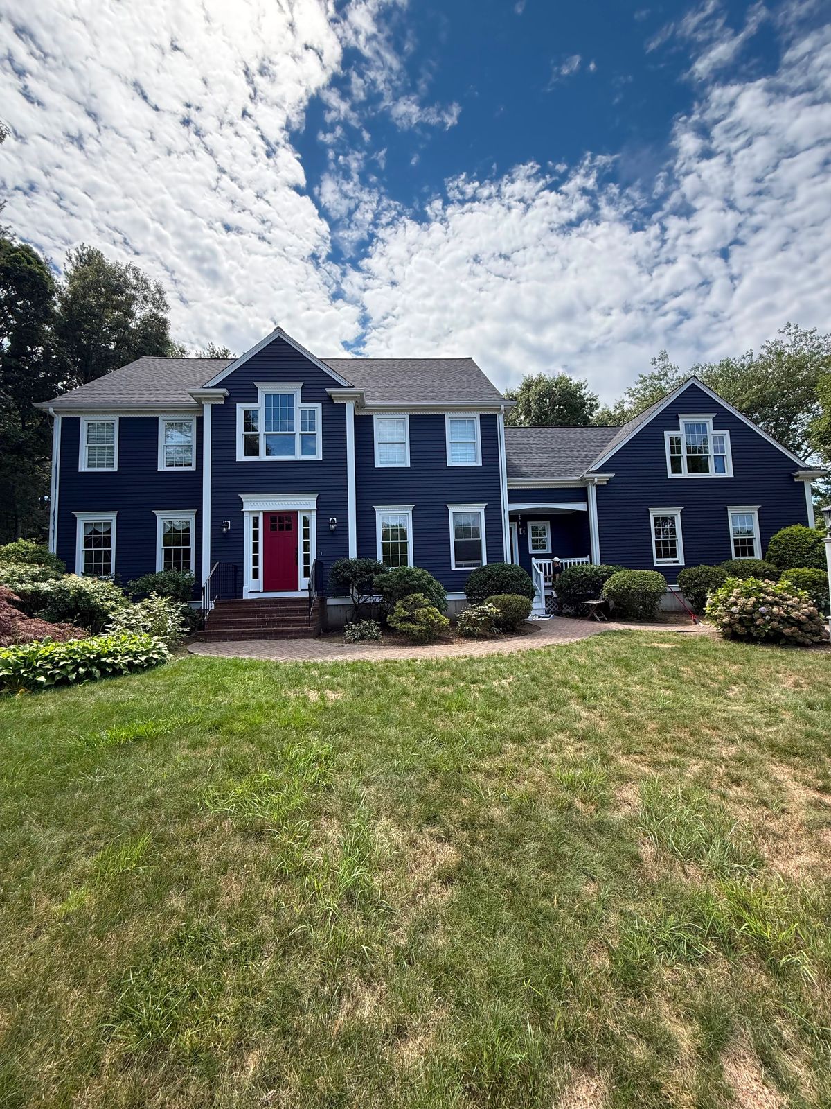 Navy blue colonial with a red front door